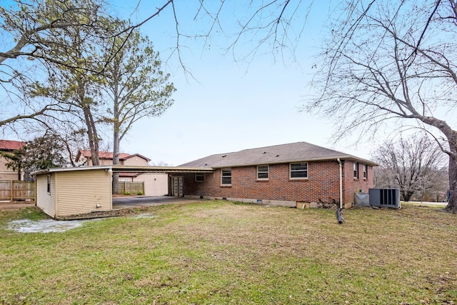 rear view of house featuring central AC, a yard, and a carport