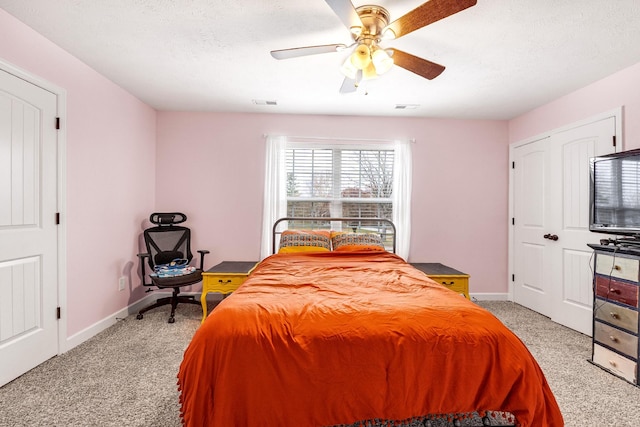 carpeted bedroom featuring a textured ceiling and ceiling fan