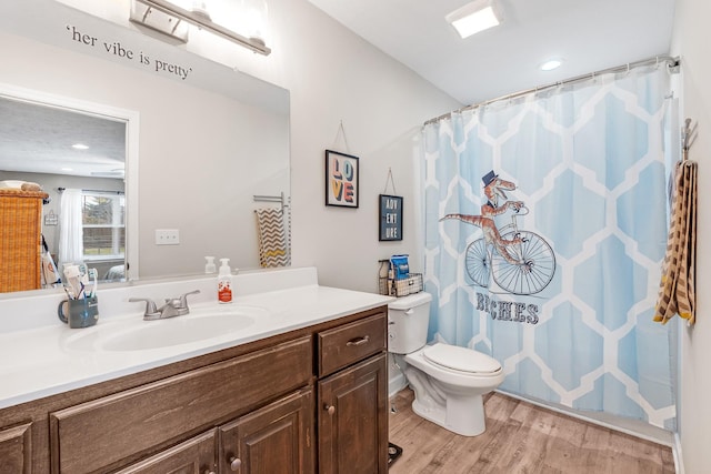 bathroom with walk in shower, vanity, wood-type flooring, and toilet