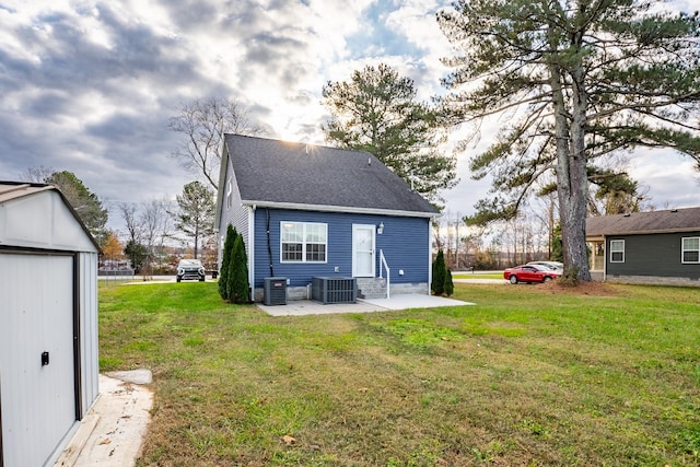 rear view of house featuring cooling unit, a patio area, and a lawn