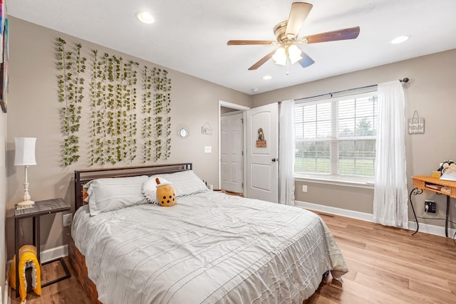 bedroom with light hardwood / wood-style floors and ceiling fan