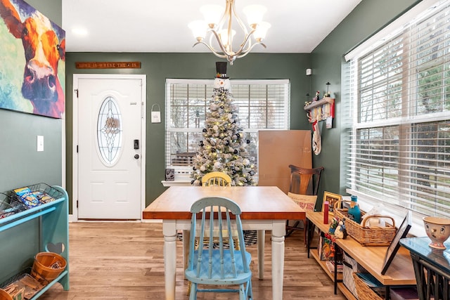 dining space with light hardwood / wood-style flooring and a notable chandelier