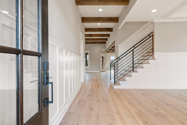 foyer featuring light hardwood / wood-style flooring and beamed ceiling