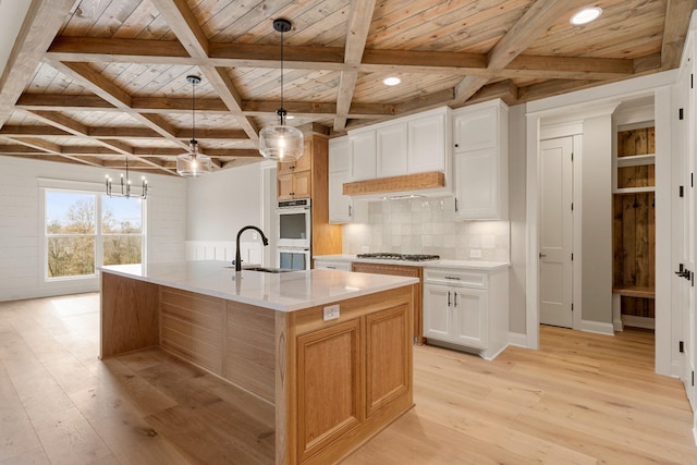 kitchen with pendant lighting, wooden ceiling, white cabinetry, and a large island