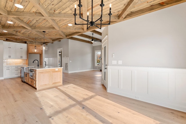 kitchen featuring a center island with sink, decorative light fixtures, light wood-type flooring, and wood ceiling