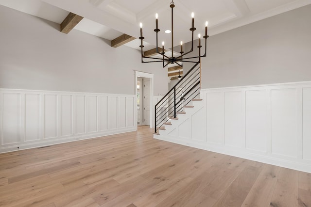 interior space with beamed ceiling, light hardwood / wood-style floors, and a chandelier