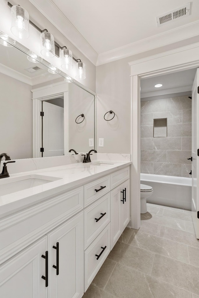 full bathroom with ornamental molding, tile patterned floors, toilet, vanity, and tiled shower / bath