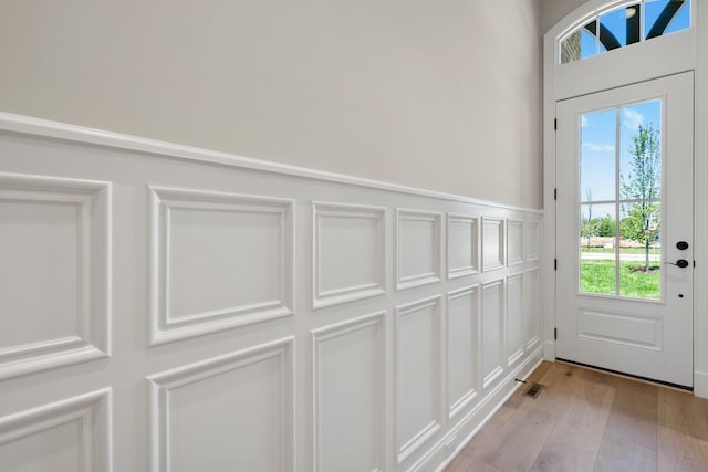 doorway with light hardwood / wood-style floors and a wealth of natural light