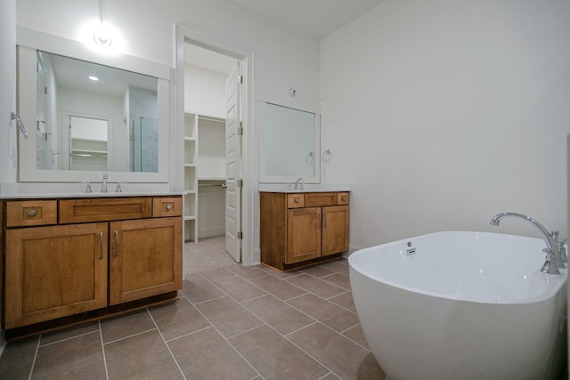 bathroom featuring shower with separate bathtub, vanity, and tile patterned floors