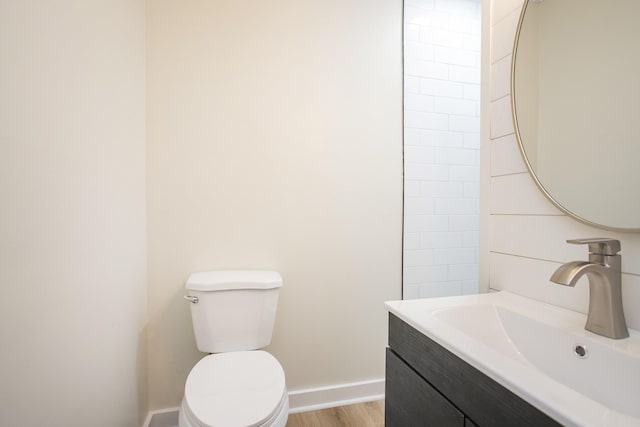 bathroom featuring wood-type flooring, vanity, and toilet