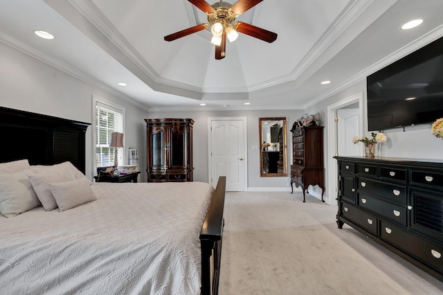 carpeted bedroom featuring ceiling fan, ornamental molding, and a tray ceiling