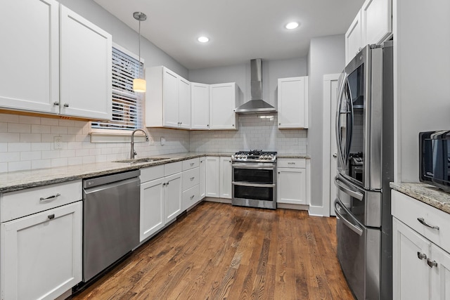 kitchen with white cabinets, dark hardwood / wood-style flooring, stainless steel appliances, and wall chimney range hood