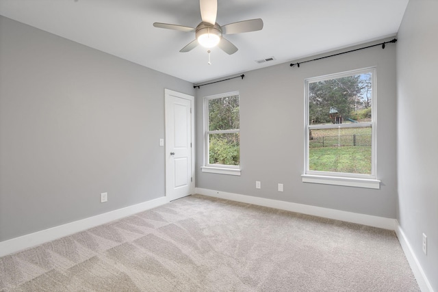 carpeted empty room featuring ceiling fan and a healthy amount of sunlight