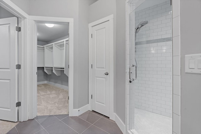 bathroom with tile patterned floors and a tile shower