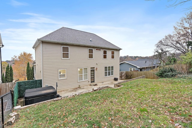 back of house featuring a patio area and a lawn