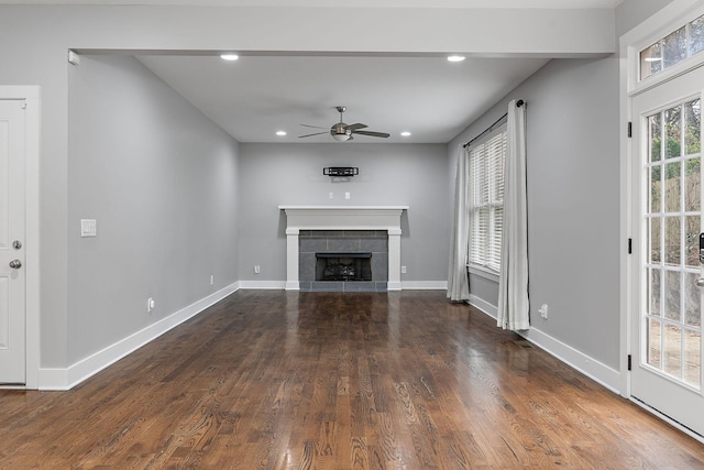 unfurnished living room featuring a fireplace, ceiling fan, and dark wood-type flooring