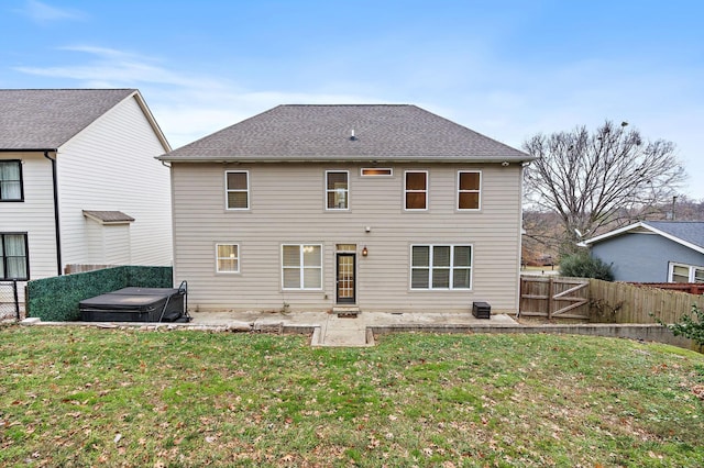 rear view of property with a patio area, a yard, and a hot tub