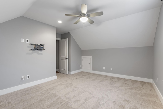 additional living space with light colored carpet, vaulted ceiling, and ceiling fan