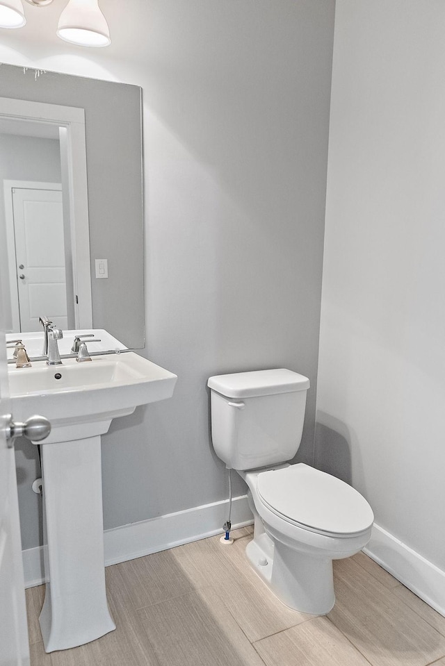 bathroom featuring hardwood / wood-style flooring, toilet, and sink