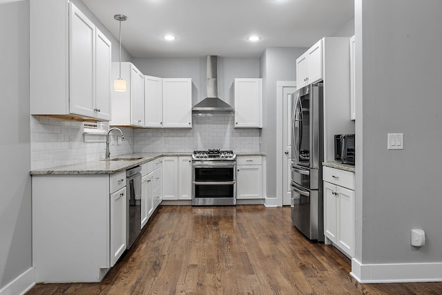 kitchen featuring appliances with stainless steel finishes, sink, wall chimney range hood, white cabinets, and dark hardwood / wood-style floors