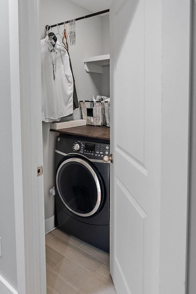 laundry area with washer / dryer and light hardwood / wood-style floors