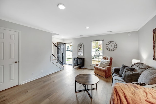 living room with light hardwood / wood-style floors and ornamental molding