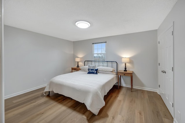 bedroom featuring a textured ceiling and light wood-type flooring