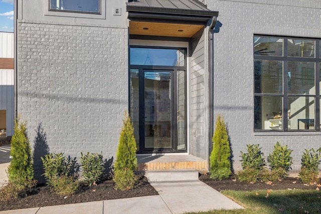 entrance to property featuring a standing seam roof and metal roof