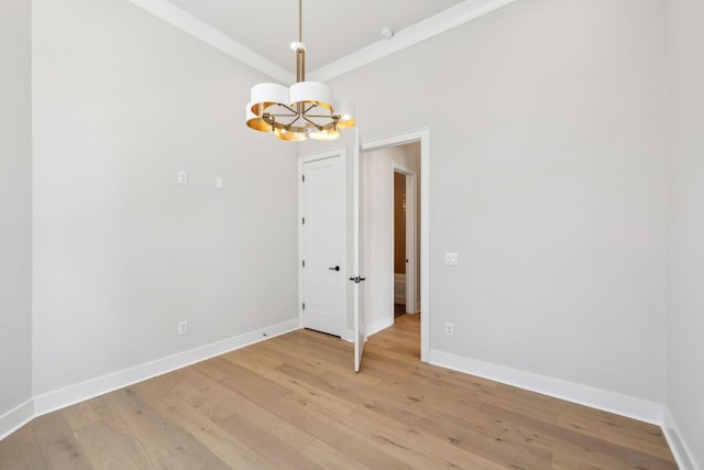 unfurnished room with baseboards, crown molding, a notable chandelier, and light wood-style floors