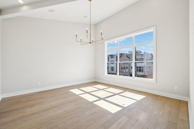 unfurnished room with light wood-style floors, baseboards, and a notable chandelier