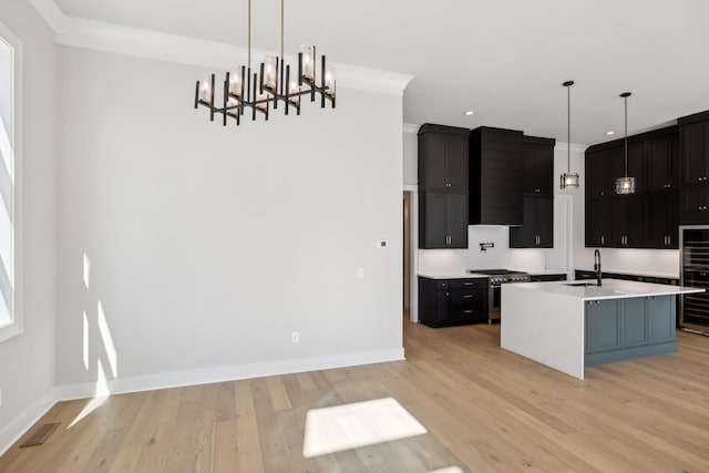 kitchen featuring light wood-style flooring, stainless steel stove, a sink, visible vents, and light countertops