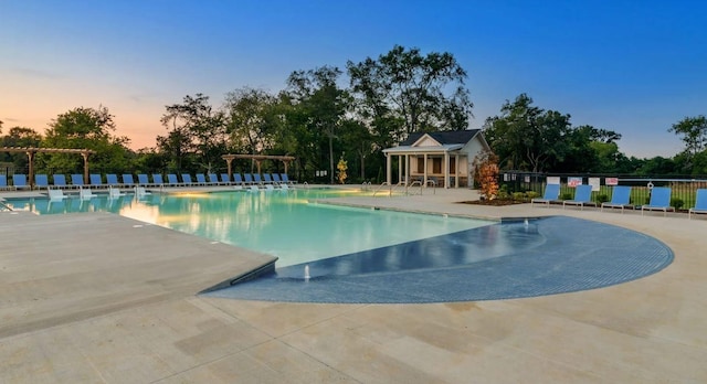 pool at dusk with a patio area