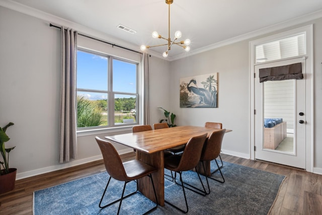 dining space featuring dark hardwood / wood-style floors, crown molding, and an inviting chandelier