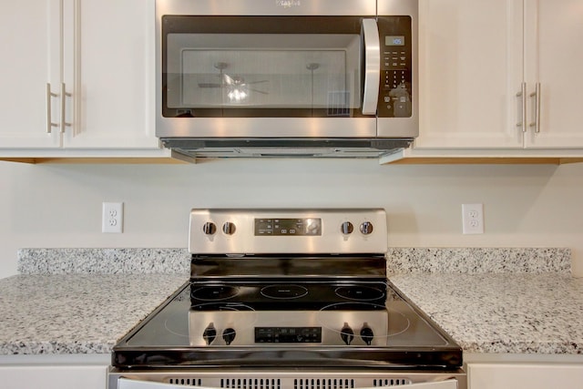 kitchen with white cabinets, light stone counters, and appliances with stainless steel finishes