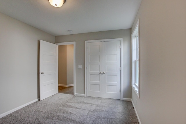 unfurnished bedroom with light colored carpet and a closet