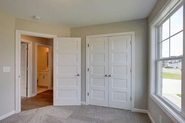 unfurnished bedroom with light carpet and a closet