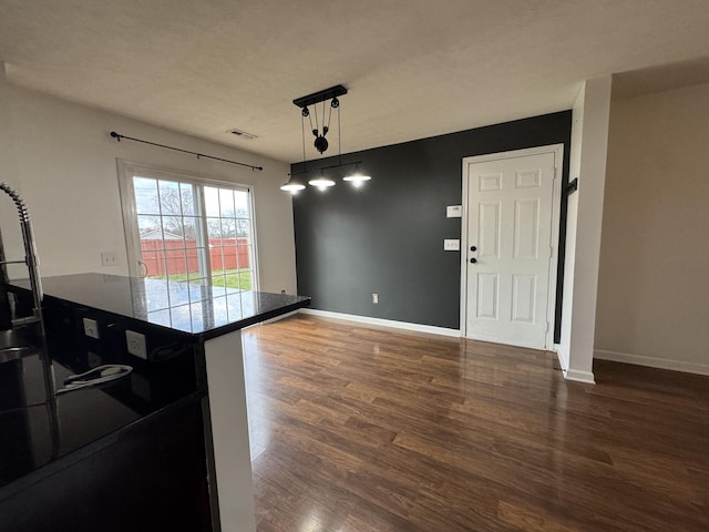 unfurnished dining area featuring a textured ceiling and dark hardwood / wood-style floors