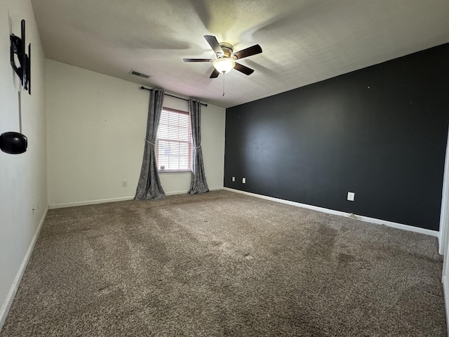 empty room featuring ceiling fan, carpet floors, and a textured ceiling