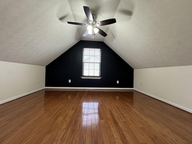 additional living space with vaulted ceiling, ceiling fan, hardwood / wood-style floors, and a textured ceiling