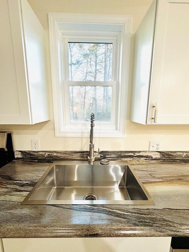 interior details with white cabinetry and sink