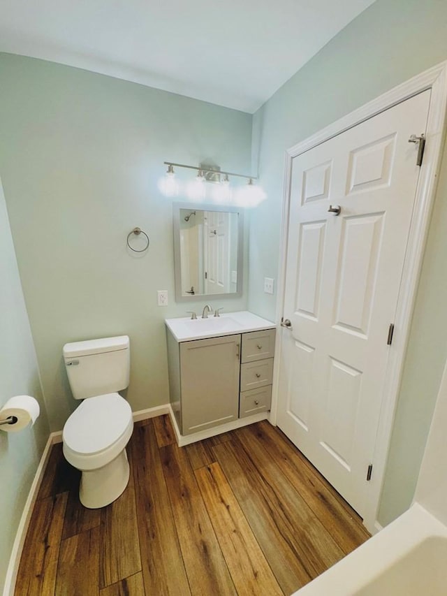 bathroom featuring wood-type flooring, vanity, and toilet