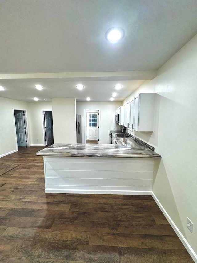 kitchen featuring kitchen peninsula, dark wood-type flooring, and appliances with stainless steel finishes