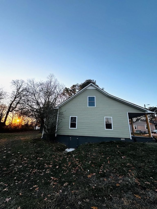 property exterior at dusk with a lawn