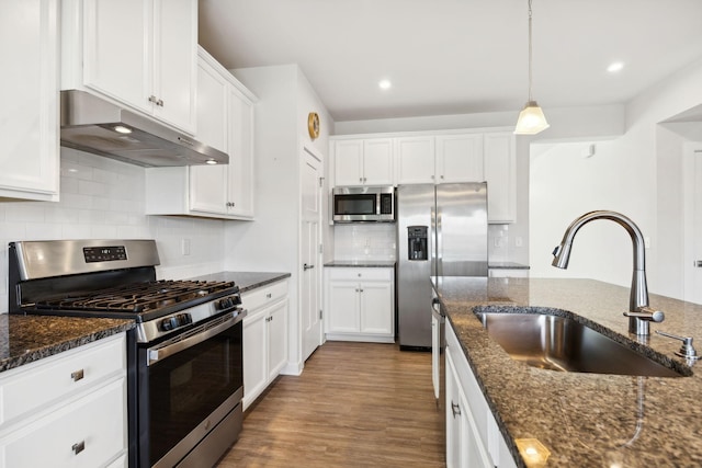 kitchen featuring dark stone counters, sink, stainless steel appliances, and wood-type flooring