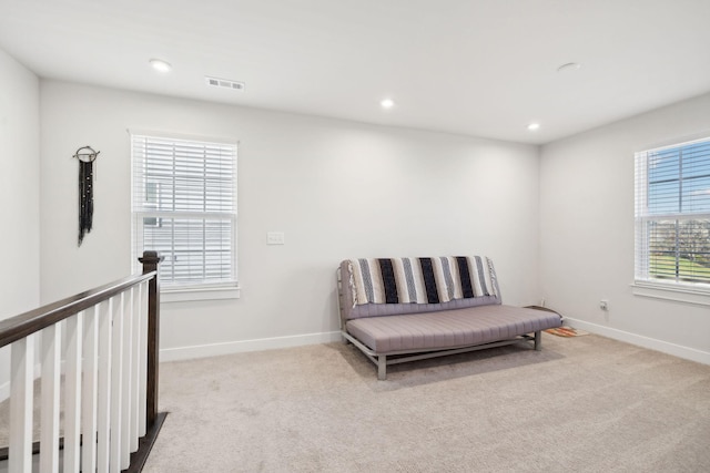 living area featuring light carpet