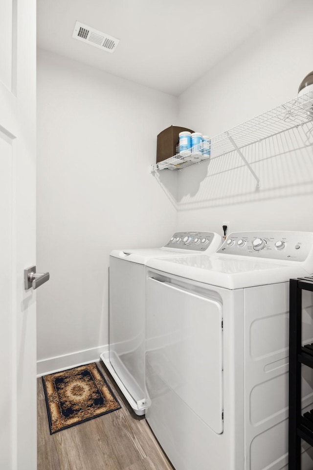 laundry room featuring wood-type flooring and independent washer and dryer