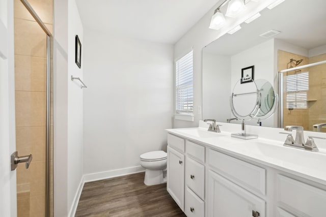 bathroom with toilet, vanity, a healthy amount of sunlight, and hardwood / wood-style flooring