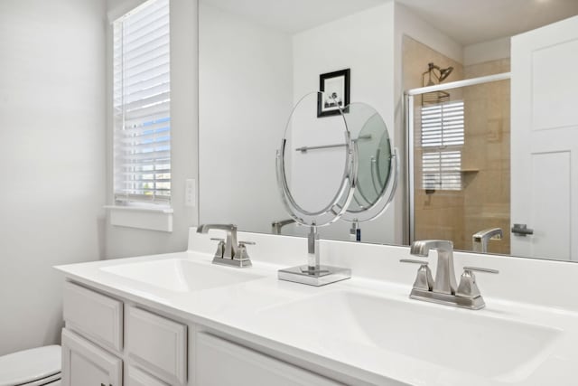 bathroom featuring vanity, toilet, and a shower with shower door