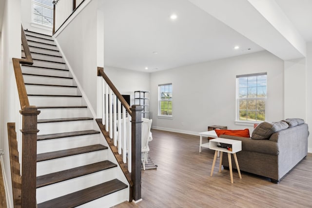 stairs with hardwood / wood-style flooring and a healthy amount of sunlight