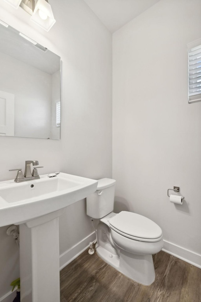 bathroom featuring hardwood / wood-style flooring, toilet, and sink